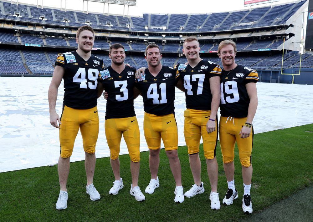 Iowa Hawkeyes linebacker Nick Niemann (49), place kicker Keith Duncan (3), defensive back Colton Dinsdale (41), linebacker Nick Anderson (47), and wide receiver Max Cooper (19) following the team photo Wednesday, December 25, 2019 at SDCCU Stadium in San Diego. (Brian Ray/hawkeyesports.com)