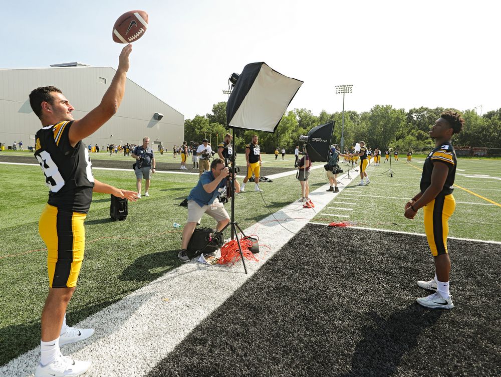 Iowa Hawkeyes wide receiver Nico Ragaini (89) tosses a ball to wide receiver Tyrone Tracy Jr. (3) as a photographer takes pictures during Iowa Football Media Day at the Hansen Football Performance Center in Iowa City on Friday, Aug 9, 2019. (Stephen Mally/hawkeyesports.com)