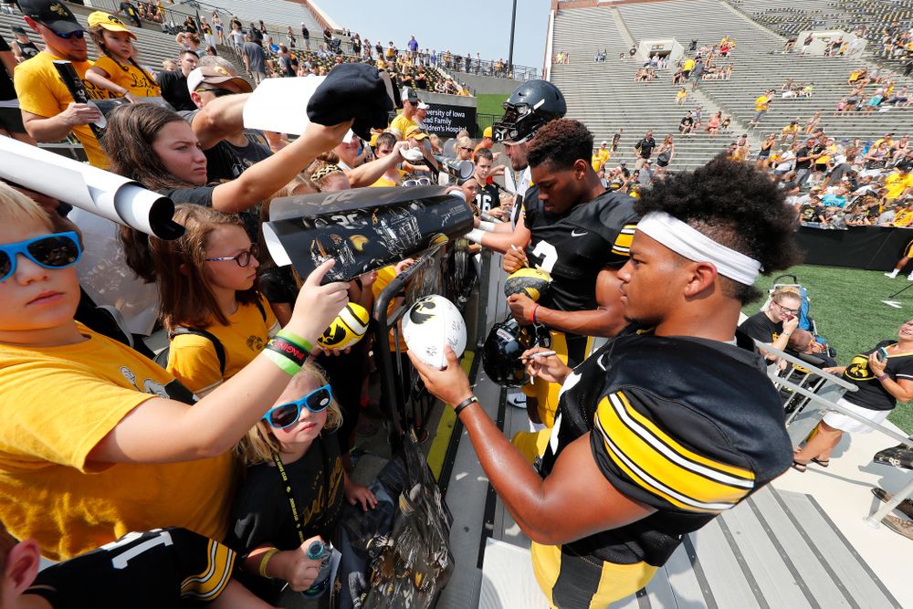 Iowa Hawkeyes running back Ivory Kelly-Martin (21) and wide receiver Tyrone Tracy Jr. (3) sign autographs during Kids Day Saturday, August 11, 2018 at Kinnick Stadium. (Brian Ray/hawkeyesports.com)