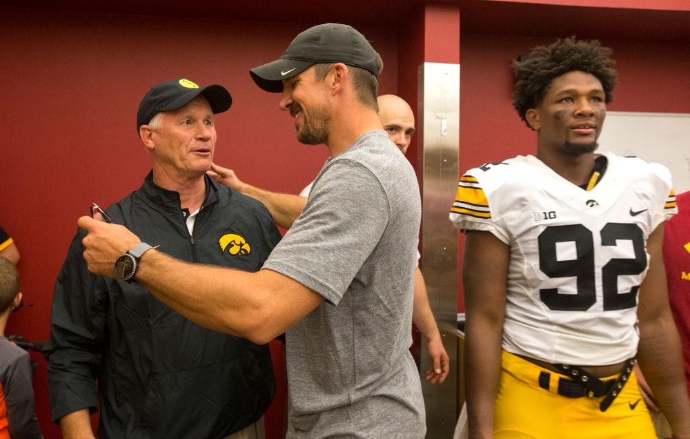 Former Iowa Hawkeyes tight end Dallas Clark talks with defensive line coach Reese Morgan as they celebrate their victory over the Iowa State Cyclones in the Iowa Corn Cy-Hawk Series Saturday, Sept. 12, 2015 at the Jack Trice Stadium in Ames.  (Brian Ray/hawkeyesports.com)