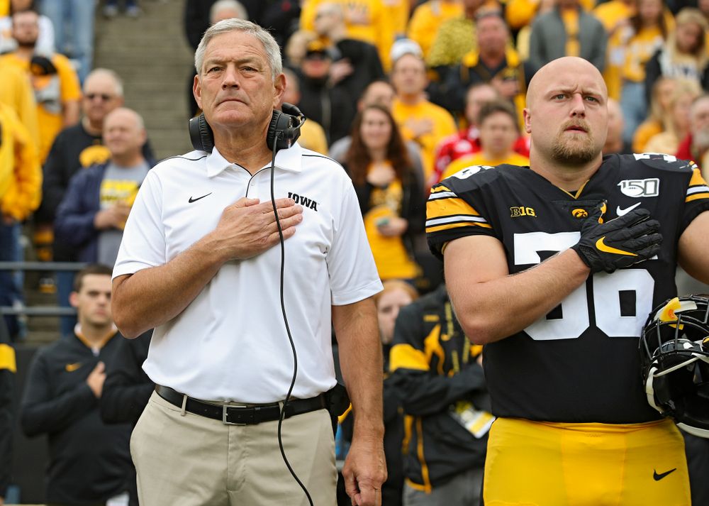Iowa Hawkeyes head coach Kirk Ferentz (from left) and fullback Brady Ross (36) stand for the National Anthem before their game at Kinnick Stadium in Iowa City on Saturday, Sep 28, 2019. (Stephen Mally/hawkeyesports.com)
