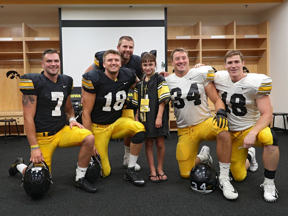 Kid Captain Aubrey Bussan-Kluesner takes a picture with Iowa football players during Kids Day at Kinnick Stadium in Iowa City on Saturday, Aug 10, 2019. (Stephen Mally/hawkeyesports.com)