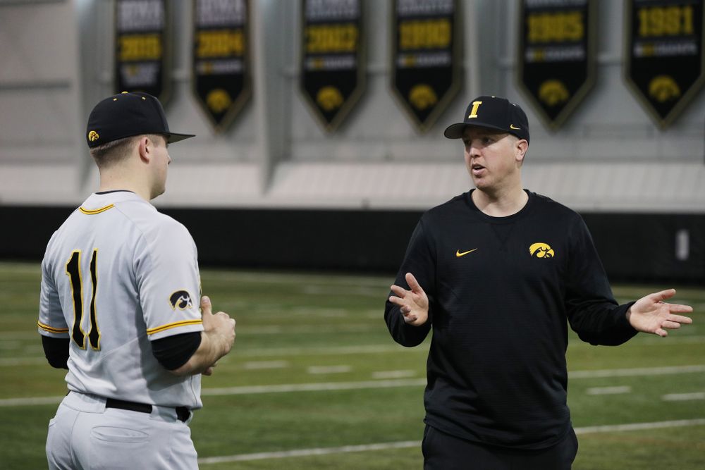 Iowa Hawkeyes Cole McDonald (11) talks with pitching coach Tom Gorzelanny during the team's annual media day Tuesday, February 5, 2019 in the Indoor Practice Facility. (Brian Ray/hawkeyesports.com)