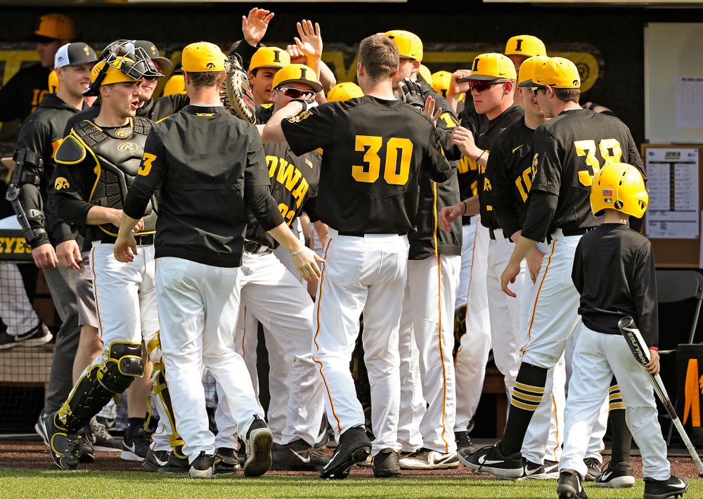 Iowa Hawkeyes right fielder Connor McCaffery (30) is greeted by teammates after scoring a run during the fourth inning of their game against Rutgers at Duane Banks Field in Iowa City on Saturday, Apr. 6, 2019. (Stephen Mally/hawkeyesports.com)