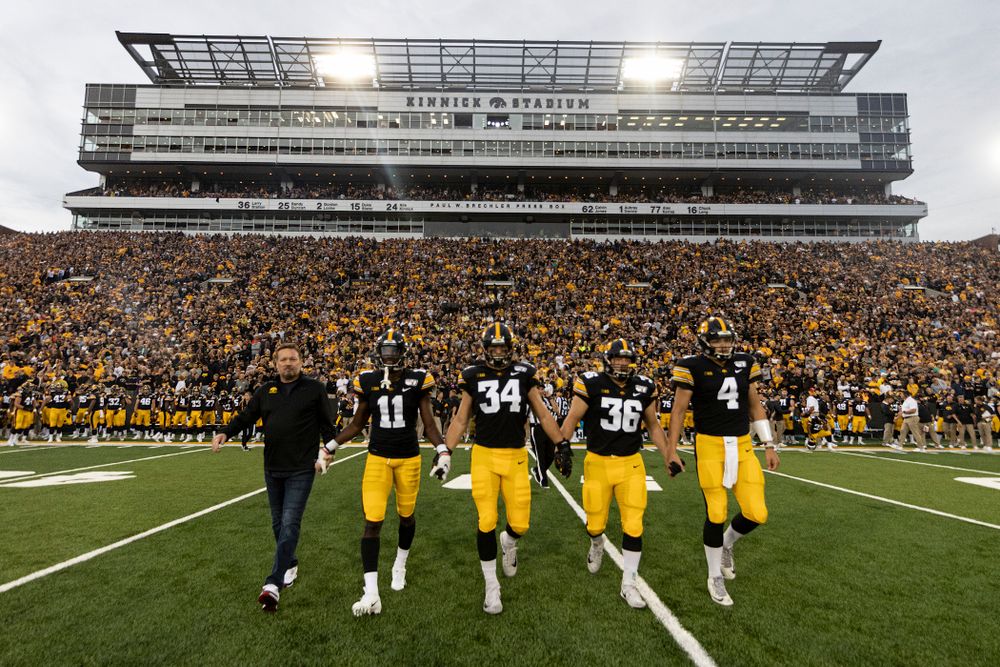 Honorary captain Bob Stopps with captains defensive back Michael Ojemudia (11), linebacker Kristian Welch (34), fullback Brady Ross (36), and quarterback Nate Stanley (4) before their game against the Miami RedHawks Saturday, August 31, 2019 at Kinnick Stadium in Iowa City. (Brian Ray/hawkeyesports.com)