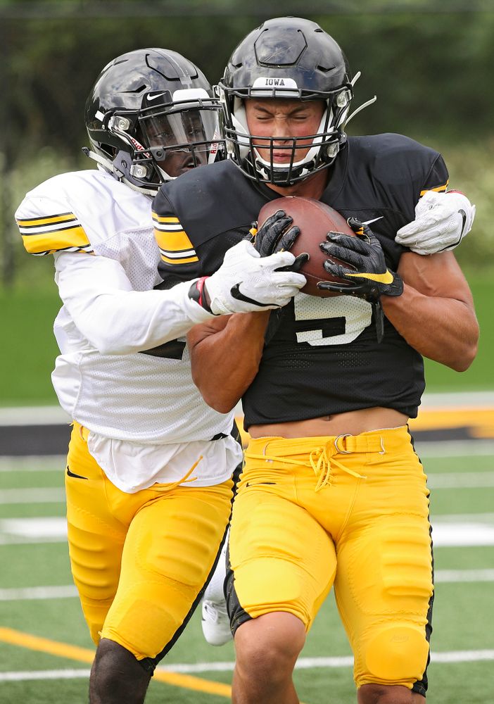 Iowa Hawkeyes wide receiver Oliver Martin (5) pulls in a pass as defensive back Michael Ojemudia (11) defends during Fall Camp Practice No. 10 at the Hansen Football Performance Center in Iowa City on Tuesday, Aug 13, 2019. (Stephen Mally/hawkeyesports.com)