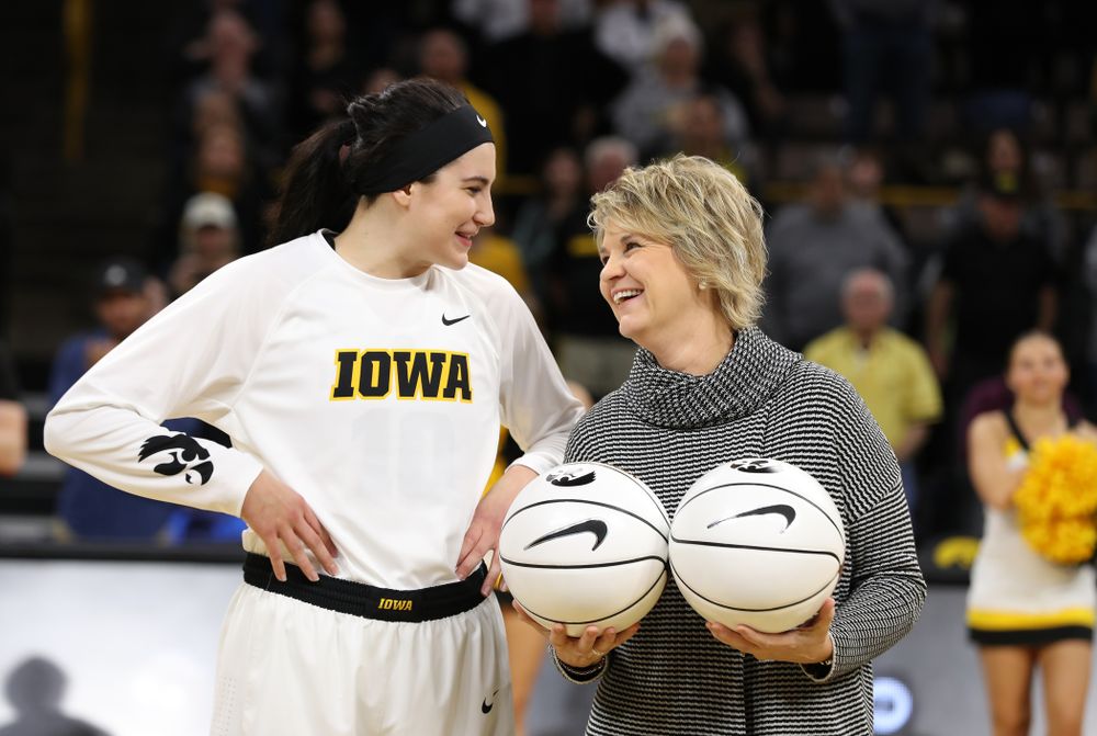 Iowa Hawkeyes forward Megan Gustafson (10) receives a pair of commemorative basketballs from head coach Lisa Bluder for becoming the school's all time rebounds leader and scoring leader before their gam eagainst the Nebraska Cornhuskers Thursday, January 3, 2019 at Carver-Hawkeye Arena. (Brian Ray/hawkeyesports.com)