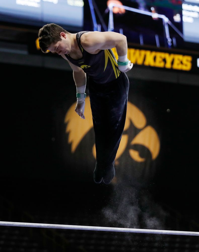 Rogelio Vazquez competes on the high bar against Illinois 