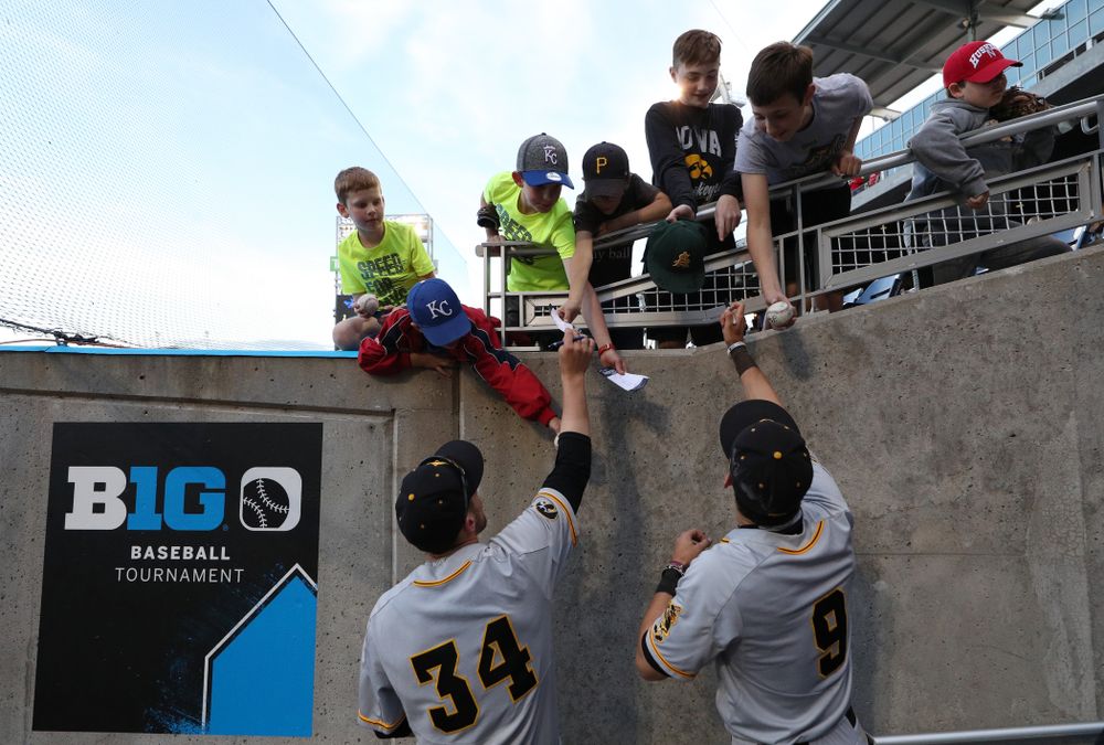 Iowa Hawkeyes catcher Austin Martin (34) and outfielder Ben Norman (9) sign autographs following their game against the Indiana Hoosiers in the first round of the Big Ten Baseball Tournament Wednesday, May 22, 2019 at TD Ameritrade Park in Omaha, Neb. (Brian Ray/hawkeyesports.com)