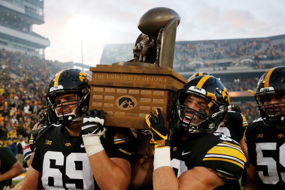 Iowa Hawkeyes offensive lineman Keegan Render (69) and defensive back Jake Gervase (30) celebrate with the Cy-Hawk trophy following their game against the Iowa State Cyclones Saturday, September 8, 2018 at Kinnick Stadium. (Brian Ray/hawkeyesports.com)