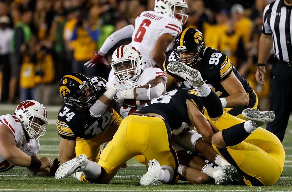 Iowa Hawkeyes linebacker Kristian Welch (34), Iowa Hawkeyes linebacker Jack Hockaday (48), and Iowa Hawkeyes defensive end Anthony Nelson (98) make a tackle during a game against Wisconsin at Kinnick Stadium on September 22, 2018. (Tork Mason/hawkeyesports.com)