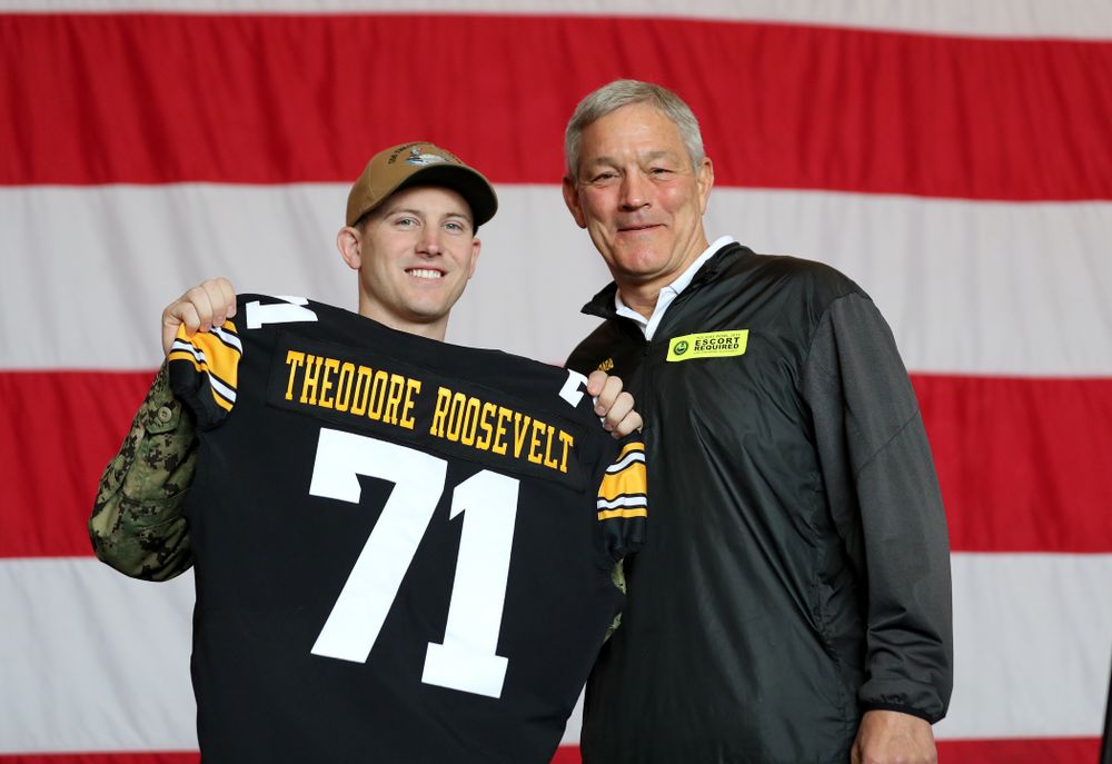Iowa Hawkeyes head coach Kirk Ferentz presents a jersey to honorary captain Vincent OÕBrien of Bell Plaine during a tour of the USS Theodore Roosevelt (CVN-71) Tuesday, December 24, 2019 at the Naval Base Coronado. (Brian Ray/hawkeyesports.com)
