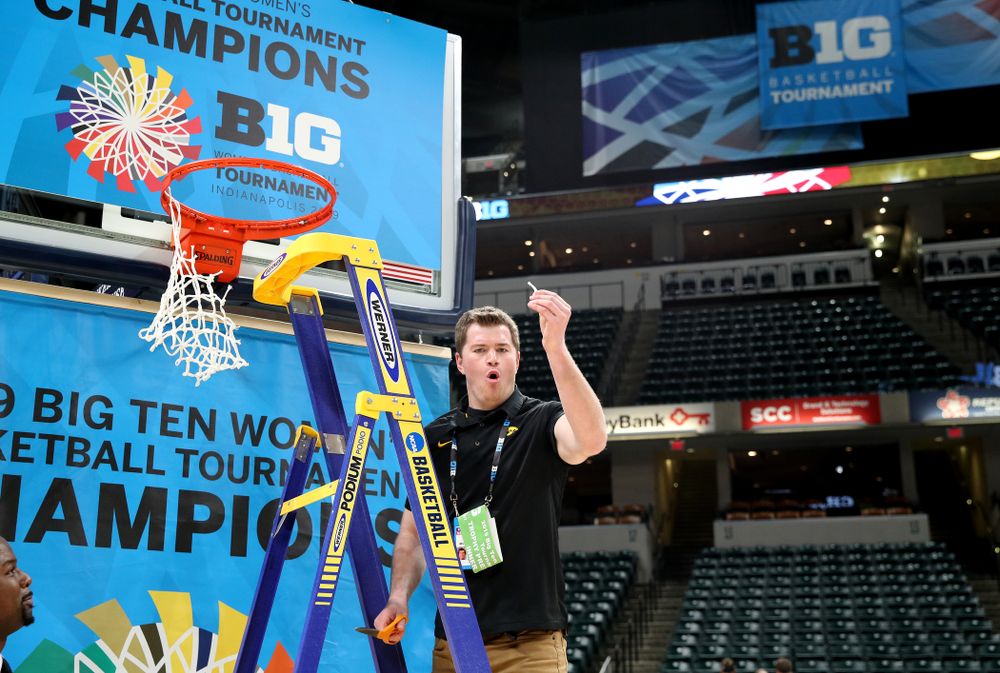 Women's Basketball videographer Zach Grant cuts down the net as they celebrate their victory over the Maryland Terrapins in the Big Ten Championship Game Sunday, March 10, 2019 at Bankers Life Fieldhouse in Indianapolis, Ind. (Brian Ray/hawkeyesports.com)