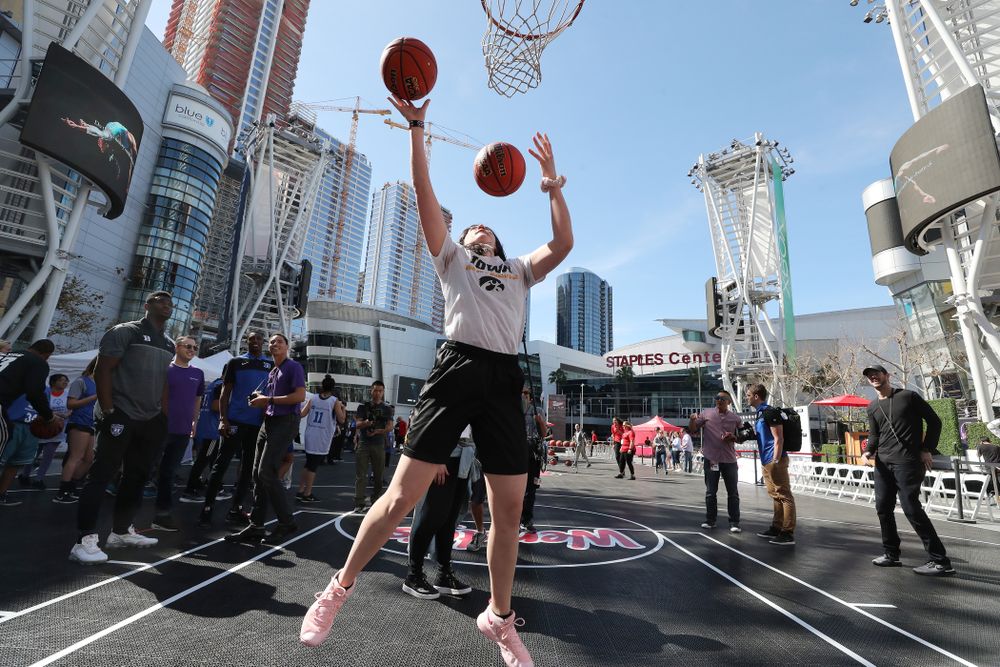 Iowa Hawkeyes forward Megan Gustafson (10) does the Mikan drill as DukeÕs Zion Williamson and RJ Barrett look on during a Special Olympics event Friday, April 12, 2019 as part of the ESPN College Basketball Awards in the XBOX Plaza at LA Live.  (Brian Ray/hawkeyesports.com)