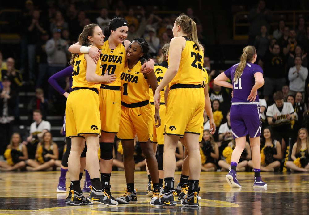 Iowa Hawkeyes forward Megan Gustafson (10) hugs forward Amanda Ollinger (43), and guard Tomi Taiwo (1) as she lives the court for the final time against the Northwestern Wildcats Sunday, March 3, 2019 at Carver-Hawkeye Arena. (Brian Ray/hawkeyesports.com)