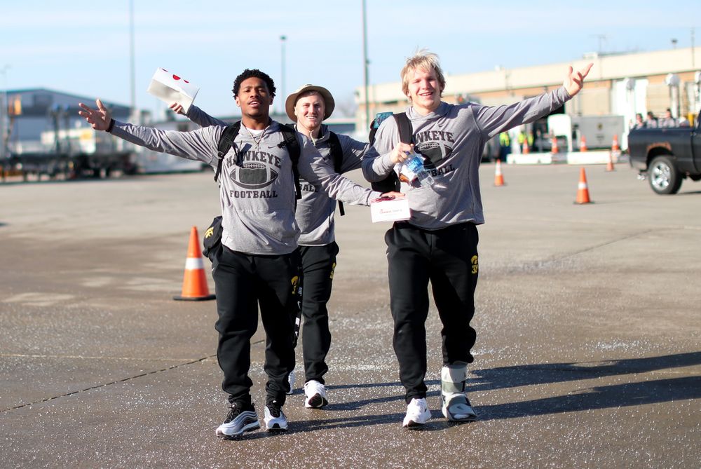 Iowa Hawkeyes wide receiver Tyrone Tracy Jr. (3), punter Michael Sleep-Dalton (22), and linebacker Monte Pottebaum (38) board the team plane at the Eastern Iowa Airport Saturday, December 21, 2019 on the way to San Diego, CA for the Holiday Bowl. (Brian Ray/hawkeyesports.com)