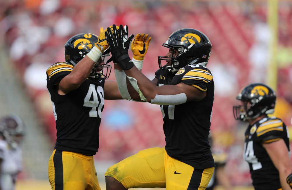 Iowa Hawkeyes defensive end Chauncey Golston (57) celebrates with linebacker Jack Hockaday (48) after intercepting a pass during the Outback Bowl Tuesday, January 1, 2019 at Raymond James Stadium in Tampa, FL. (Brian Ray/hawkeyesports.com)