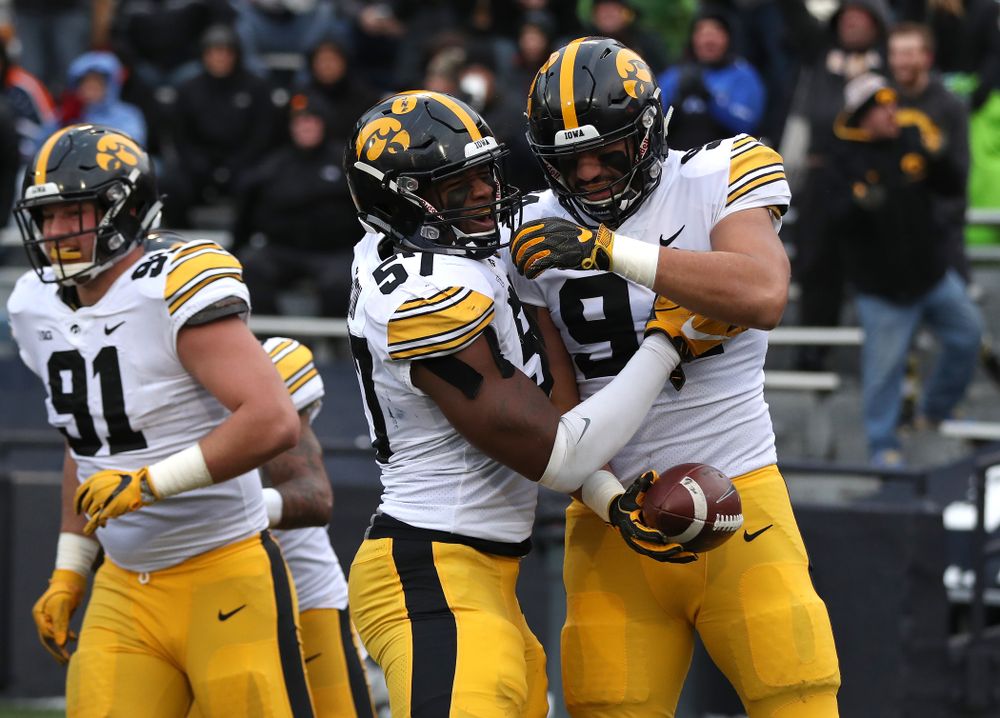 Iowa Hawkeyes defensive end A.J. Epenesa (94) celebrates with defensive end Chauncey Golston (57) after scoring against the Illinois Fighting Illini Saturday, November 17, 2018 at Memorial Stadium in Champaign, Ill. (Brian Ray/hawkeyesports.com)