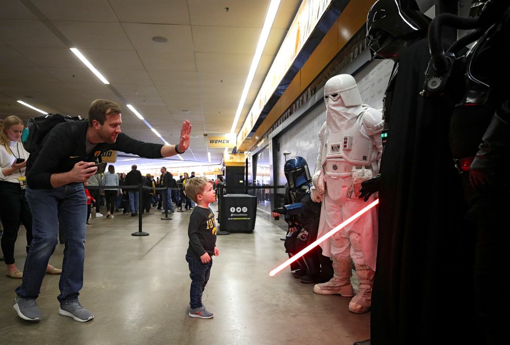 A young Hawkeyes fan gives Darth Vader a high-five on the concourse before the game at Carver-Hawkeye Arena in Iowa City on Sunday, December 29, 2019. (Stephen Mally/hawkeyesports.com)