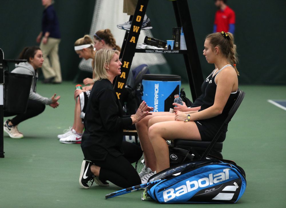Head Coach Sasha Schmid talks with Ashleigh Jacobs and Sophie Clark as they play a doubles match against the Penn State Nittany Lions Sunday, February 24, 2019 at the Hawkeye Tennis and Recreation Complex. (Brian Ray/hawkeyesports.com)