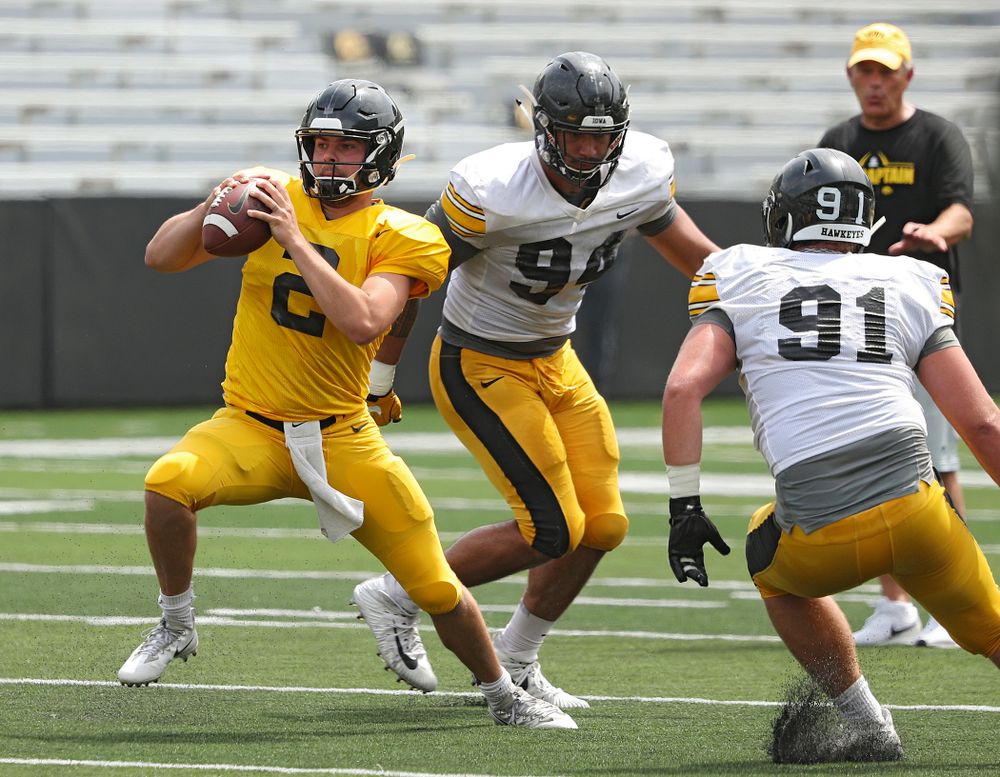Iowa Hawkeyes quarterback Peyton Mansell (2) steps forward after he was caught between defensive end A.J. Epenesa (94) and defensive lineman Brady Reiff (91) during Fall Camp Practice No. 8 at Kids Day at Kinnick Stadium in Iowa City on Saturday, Aug 10, 2019. (Stephen Mally/hawkeyesports.com)