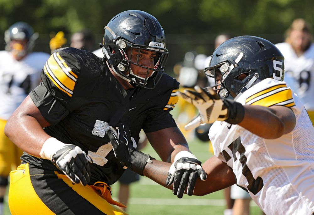 Iowa Hawkeyes offensive lineman Tristan Wirfs (74) and defensive end Chauncey Golston (57) run a drill during Fall Camp Practice #5 at the Hansen Football Performance Center in Iowa City on Tuesday, Aug 6, 2019. (Stephen Mally/hawkeyesports.com)