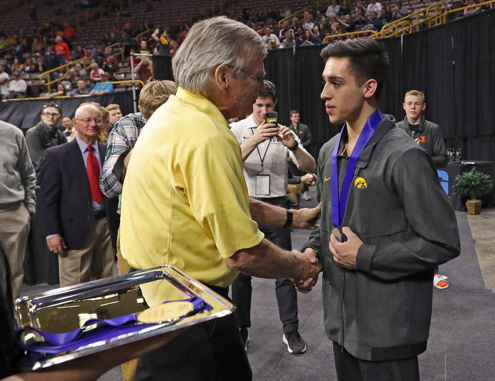 Iowa's Andrew Herrador receives a silver medal for his second place finish in the parallel bars during the second day of the Big Ten Men's Gymnastics Championships at Carver-Hawkeye Arena in Iowa City on Saturday, Apr. 6, 2019. (Stephen Mally/hawkeyesports.com)
