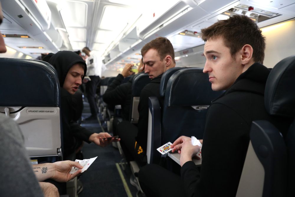Iowa Hawkeyes guard Connor McCaffery (30), guard Austin Ash (13), forward Jack Nunge (2) forward Nicholas Baer (51) play cards on a flight to Columbus for the first and second rounds of the 2019 NCAA Men's Basketball Tournament Wednesday, March 20, 2019 at the Eastern Iowa Airport. (Brian Ray/hawkeyesports.com)
