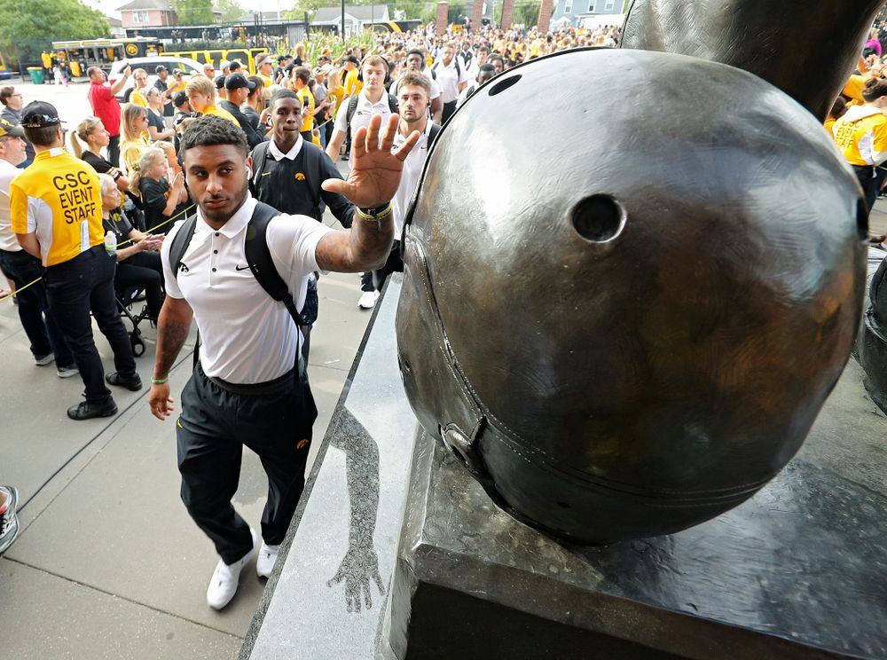 Iowa Hawkeyes defensive back Geno Stone (9) touches the helmet on the Nile Kinnick statue as the team arrives before their Big Ten Conference football game at Kinnick Stadium in Iowa City on Saturday, Sep 7, 2019. (Stephen Mally/hawkeyesports.com)