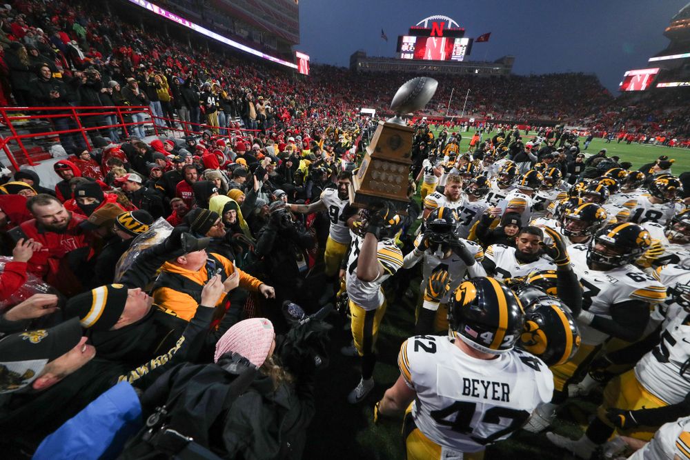 Iowa Hawkeyes defensive end Chauncey Golston (57) carries the Heroes Game trophy off the field following their win against the Nebraska Cornhuskers Friday, November 29, 2019 at Memorial Stadium in Lincoln, Neb. (Brian Ray/hawkeyesports.com)