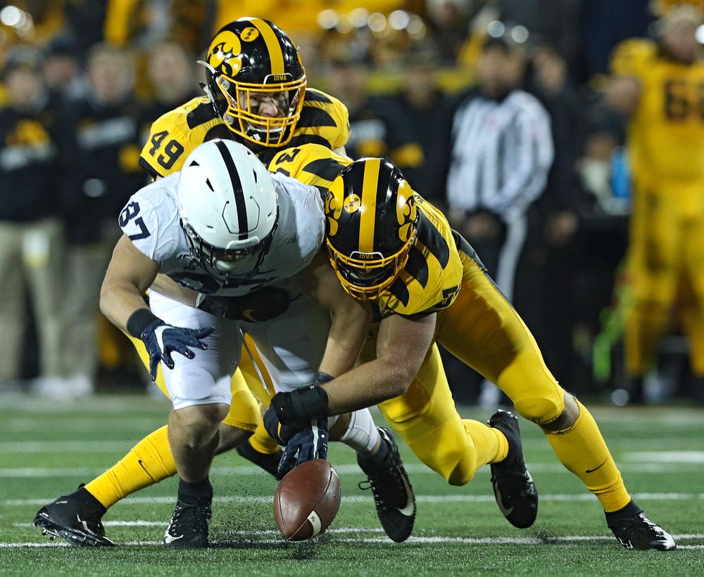 Iowa Hawkeyes linebacker Nick Niemann (49) and linebacker Kristian Welch (34) hit Penn State Nittany Lions tight end Pat Freiermuth (87) and cause him to drop a pass during the second quarter of their game at Kinnick Stadium in Iowa City on Saturday, Oct 12, 2019. (Stephen Mally/hawkeyesports.com)