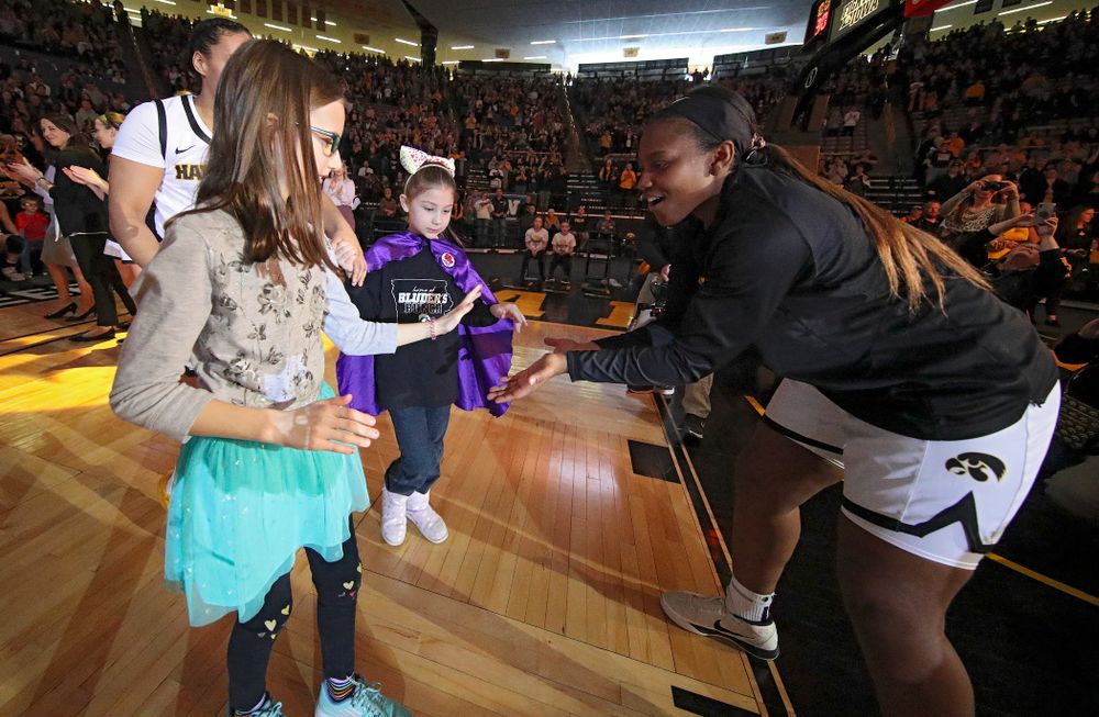 Iowa Hawkeyes guard Alexis Sevillian (right) gets a high-five from two Go Red for Women Movement Heart Champions before the start of their game at Carver-Hawkeye Arena in Iowa City on Sunday, January 26, 2020. (Stephen Mally/hawkeyesports.com)