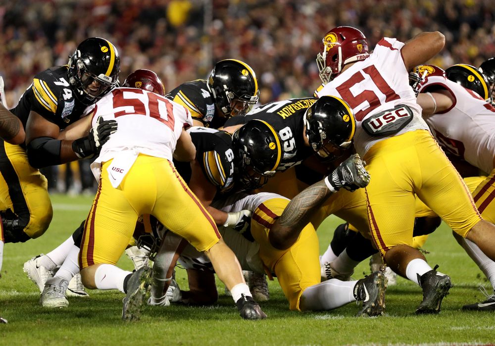 Iowa Hawkeyes offensive lineman Tyler Linderbaum (65) leads the way for quarterback Nate Stanley (4) against USC in the Holiday Bowl Friday, December 27, 2019 at San Diego Community Credit Union Stadium.  (Brian Ray/hawkeyesports.com)