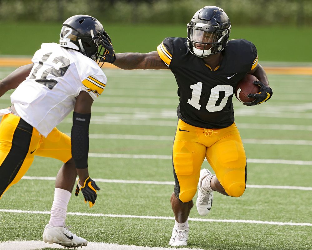 Iowa Hawkeyes running back Mekhi Sargent (10) tries to hold off defensive back D.J. Johnson (12) during Fall Camp Practice No. 10 at the Hansen Football Performance Center in Iowa City on Tuesday, Aug 13, 2019. (Stephen Mally/hawkeyesports.com)