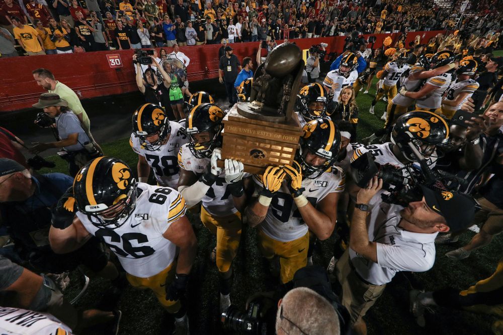 Iowa Hawkeyes defensive end Chauncey Golston (57) and defensive end A.J. Epenesa (94) carry the Cy-Hawk trophy off the field following their game against the Iowa State Cyclones Saturday, September 14, 2019 in Ames, Iowa. (Brian Ray/hawkeyesports.com)