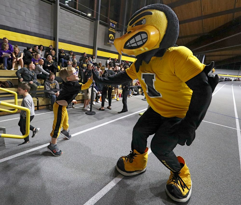 Herky gets a high-five from a young fan before the Herky Kid’s Race during the Jimmy Grant Invitational at the Recreation Building in Iowa City on Saturday, December 14, 2019. (Stephen Mally/hawkeyesports.com)