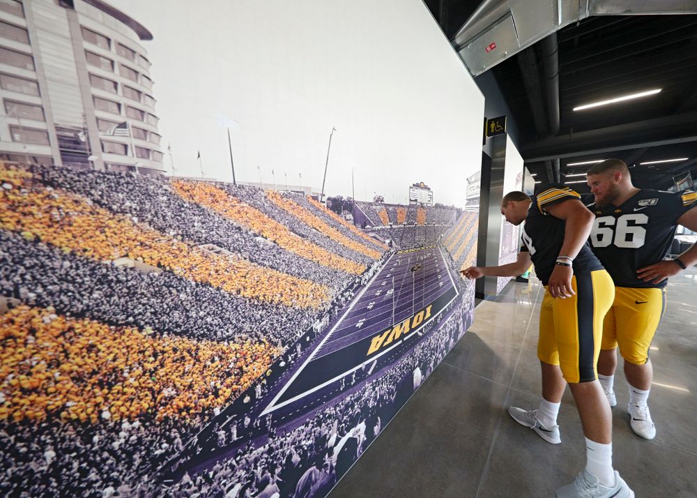 Iowa Hawkeyes quarterback Nate Stanley (4) and offensive lineman Levi Paulsen (66) look at a picture in the new Ted Pacha Family Club at Kinnick Stadium in Iowa City on Friday, Aug 9, 2019. (Stephen Mally/hawkeyesports.com)