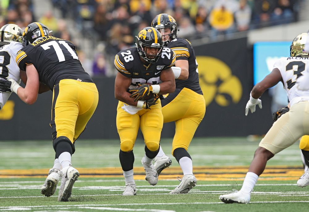 Iowa Hawkeyes running back Toren Young (28) takes a handoff from quarterback Nate Stanley (4) during the first quarter of their game at Kinnick Stadium in Iowa City on Saturday, Oct 19, 2019. (Stephen Mally/hawkeyesports.com)
