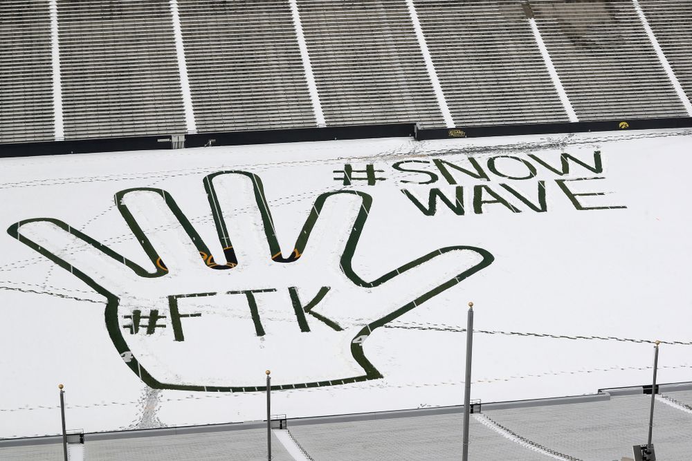 Members of the Iowa Athletics Turf Management staff create the #SnowWave for kids in the Stead Family Children's Hospital Thursday, February