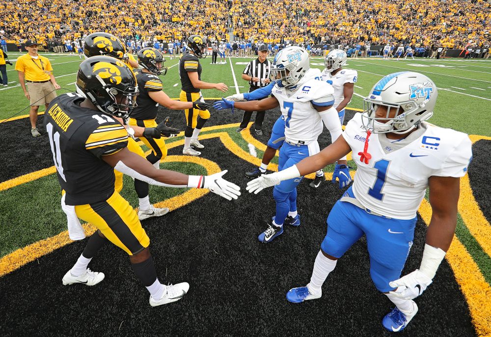 Iowa Hawkeyes captains defensive back Michael Ojemudia (11), linebacker Kristian Welch (34), fullback Brady Ross (36), and quarterback Nate Stanley (4) shake hands with the Middle Tennessee State captains before their game at Kinnick Stadium in Iowa City on Saturday, Sep 28, 2019. (Stephen Mally/hawkeyesports.com)