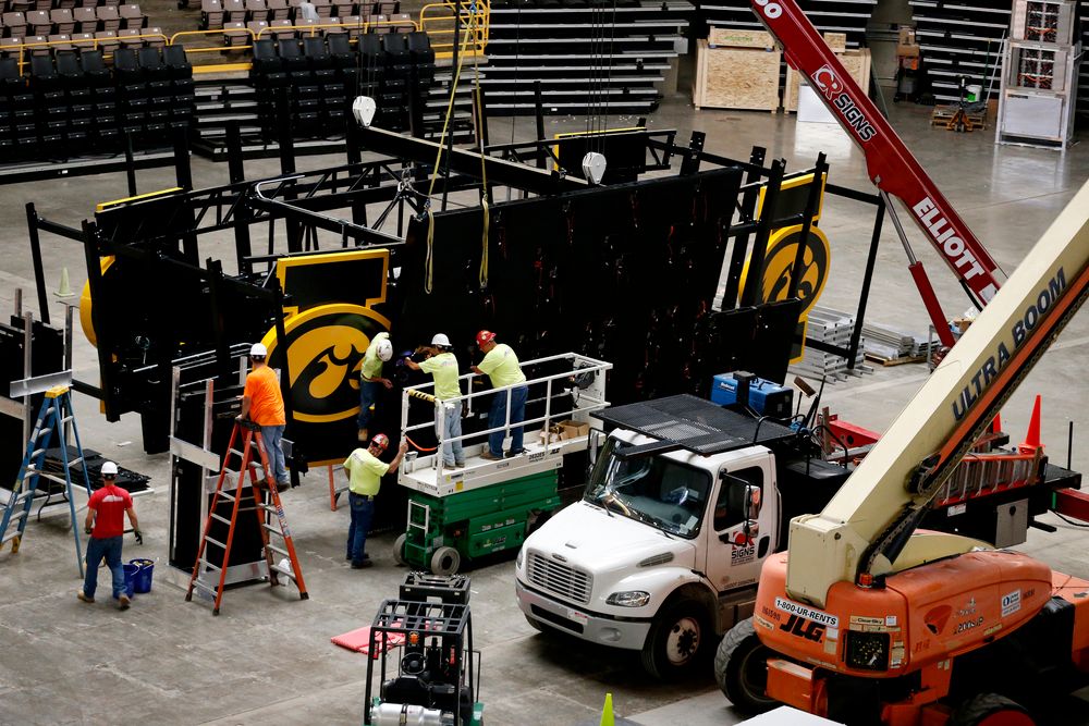 Workers install the panels on the new centerhung video board