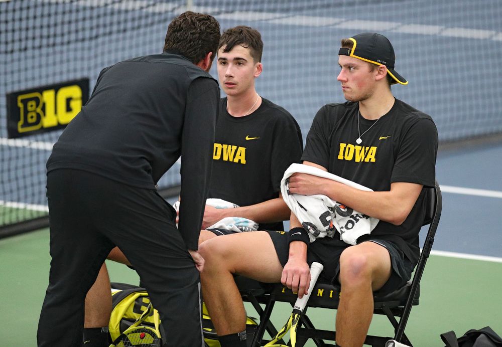 Iowa’s Mellecker Family head men’s tennis coach Ross Wilson (from left) talks with Matt Clegg and Joe Tyler during their doubles match against Marquette at the Hawkeye Tennis and Recreation Complex in Iowa City on Saturday, January 25, 2020. (Stephen Mally/hawkeyesports.com)