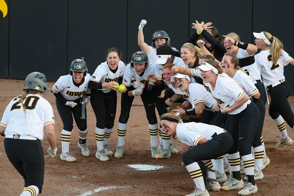 Iowa designated player Miranda Schulte (20) is greeted by teammates at home plate after hitting a home run during the sixth inning of their game against Ohio State at Pearl Field in Iowa City on Friday, May. 3, 2019. (Stephen Mally/hawkeyesports.com)