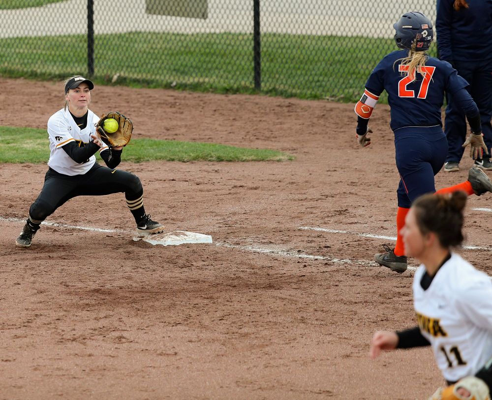 Iowa second baseman Aralee Bogar (2) fields a throw from third baseman Mallory Kilian (11) at first base for an out on a bunt play during the fifth inning of their game against Illinois at Pearl Field in Iowa City on Friday, Apr. 12, 2019. (Stephen Mally/hawkeyesports.com)