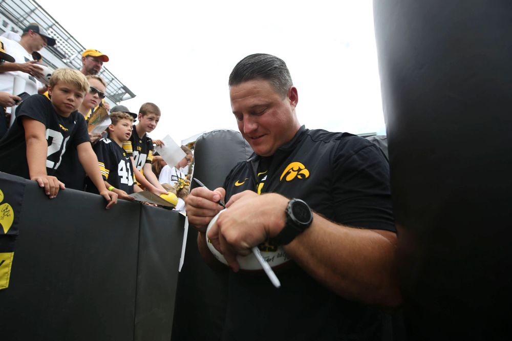 Iowa Hawkeyes offensive coordinator Brian Ferentz signs autographs during Kids Day at Kinnick Stadium on Saturday, August 10, 2019. (Lily Smith/hawkeyesports.com)