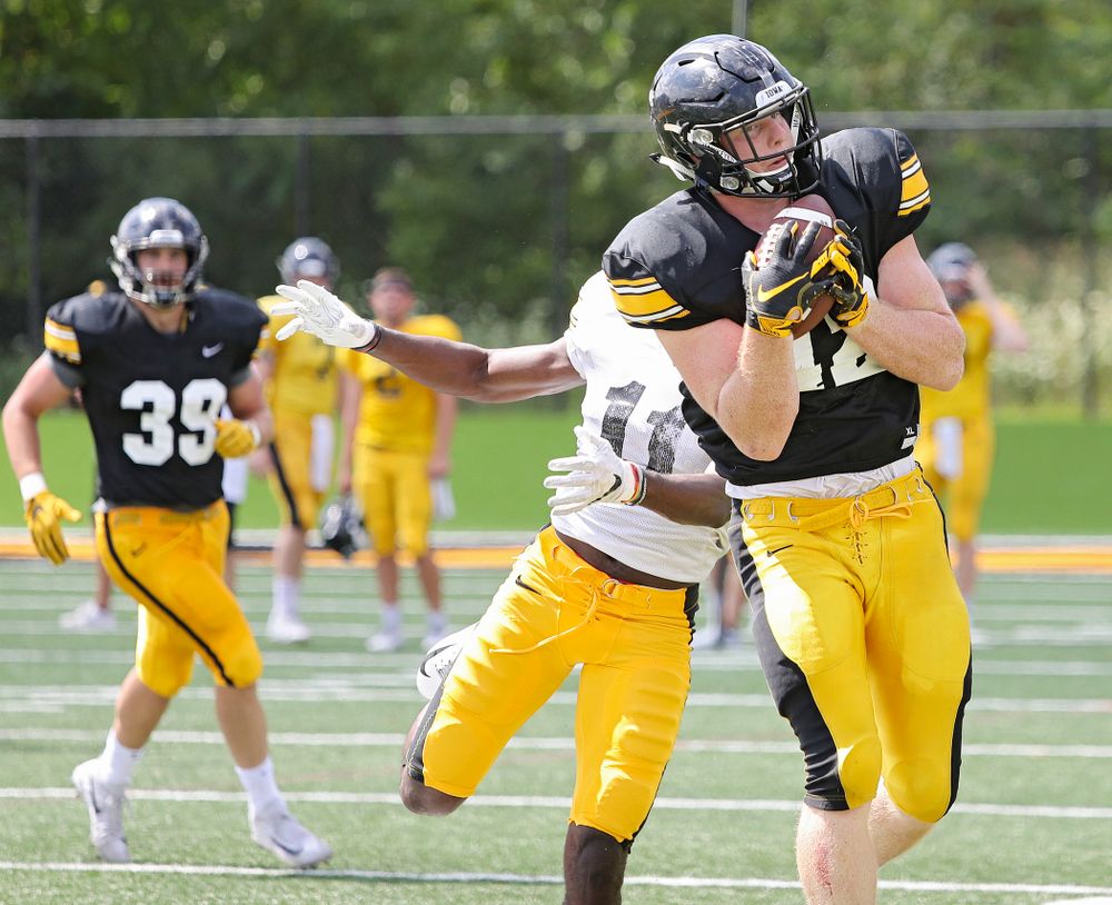 Iowa Hawkeyes tight end Shaun Beyer (42) pulls in a pass around defensive back Michael Ojemudia (11) during Fall Camp Practice #5 at the Hansen Football Performance Center in Iowa City on Tuesday, Aug 6, 2019. (Stephen Mally/hawkeyesports.com)
