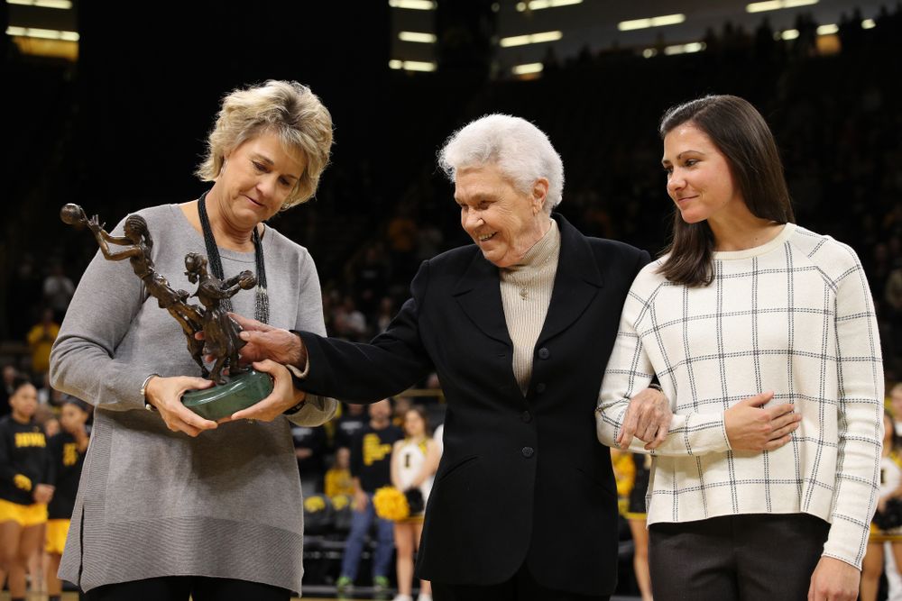 Former University of Iowa Director of Intercollegiate Athletics for Women Dr. Christine Grant receives her trophy for being inducted into the WomenÕs Basketball Hall of Fame from Iowa Hawkeyes head coach Lisa Bluder and director of basketball operations Kathryn Reynolds 
  before their game against the Robert Morris Colonials Sunday, December 2, 2018 at Carver-Hawkeye Arena. (Photo by Brian Ray)
