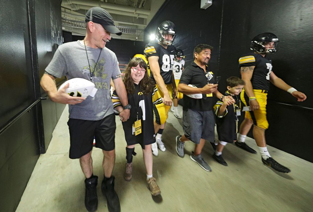 Kid Captain Lucy Roth walks with Iowa Hawkeyes long snapper Nate Vejvoda (85) during Kids Day at Kinnick Stadium in Iowa City on Saturday, Aug 10, 2019. (Stephen Mally/hawkeyesports.com)