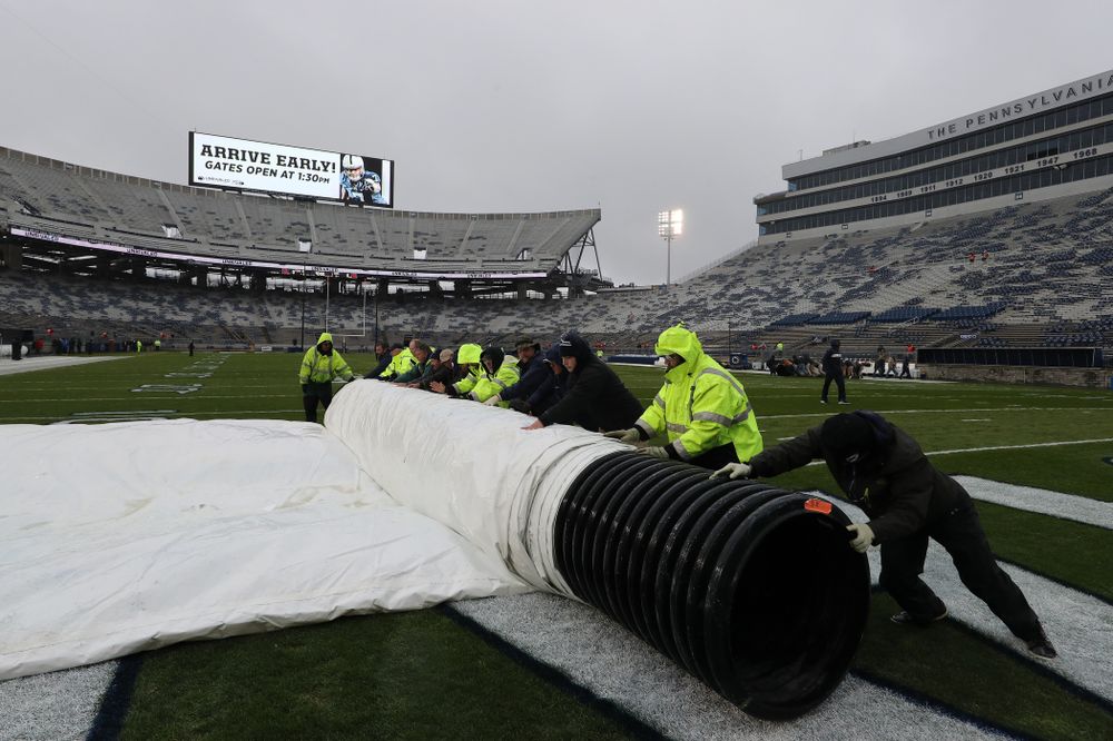 The grounds crew rolls up the tarps before the Iowa Hawkeyes game against the Penn State Nittany Lions Saturday, October 27, 2018 at Beaver Stadium in University Park, Pa. (Brian Ray/hawkeyesports.com)