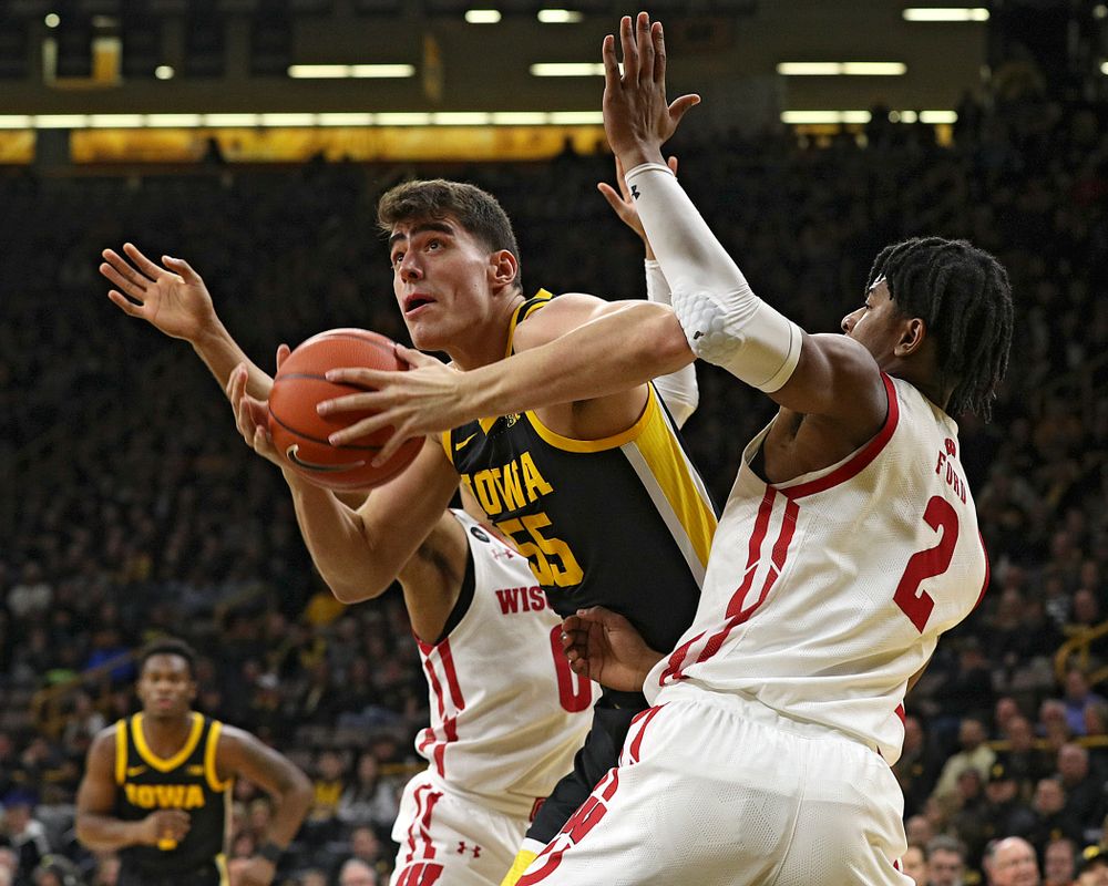 Iowa Hawkeyes center Luka Garza (55) splits two defenders during the first half of their game at Carver-Hawkeye Arena in Iowa City on Monday, January 27, 2020. (Stephen Mally/hawkeyesports.com)